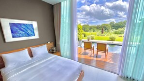 Ein Hotelzimmer mit einem großen Bett, einem gerahmten Bild an der Wand und Blick auf Pool und Garten durch das Fenster.