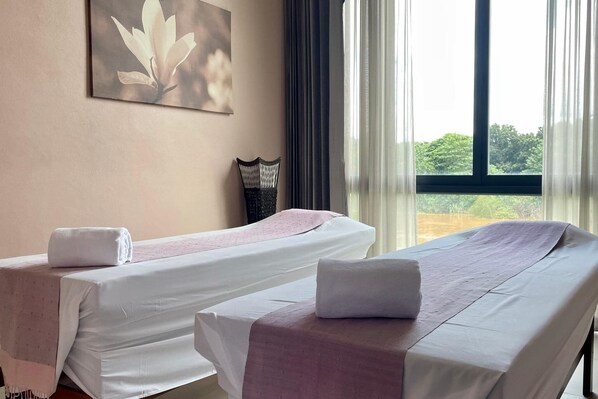 Two single beds with white linens and pink accents, a wall-mounted artwork of a flower, and a view of greenery through a window. - Zensala Riverpark Resort (Chiang Mai)