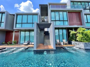 A modern hotel with a swimming pool, large windows, and a covered staircase. - Zensala Riverpark Resort (Chiang Mai)