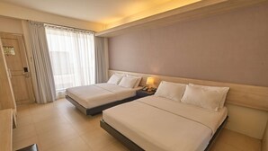 Habitación de hotel con dos camas, un escritorio y una silla.