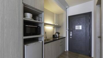 A modern kitchen with a microwave, refrigerator, and sink.