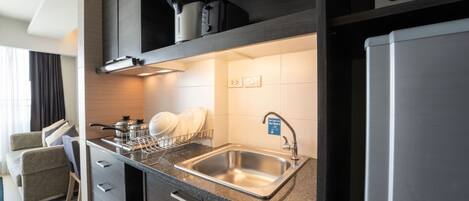 A modern kitchen with a stainless steel sink, a dish drying rack, and a built-in oven.