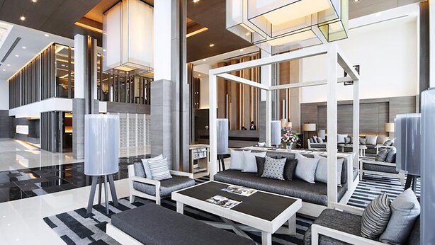 A spacious lobby with a central seating area, high ceilings, and modern lighting fixtures.