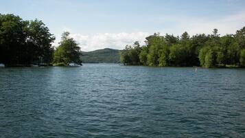 Un lac paisible, entouré d’une forêt dense et de collines.