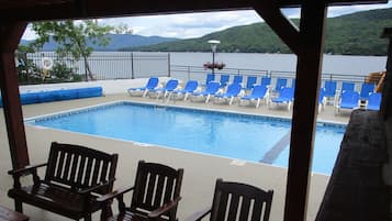 Una piscina al aire libre de temporada, sillones reclinables de piscina