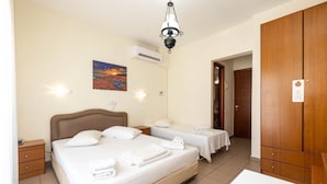Habitación de hotel con una cama grande, dos mesitas de noche, un armario y un cuadro en la pared.