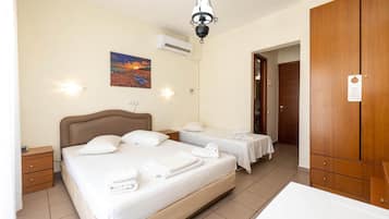 A hotel room with a large bed, two bedside tables, a wardrobe, and a painting on the wall.