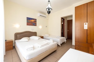 Habitación de hotel con una cama grande, dos mesitas de noche, un armario y un cuadro en la pared.
