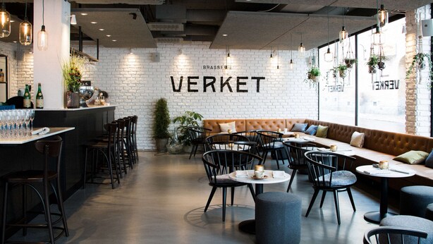 A modern cafe interior with a brick wall, wooden bar, and seating area. - Scandic Sundsvall City (Sundsvall)