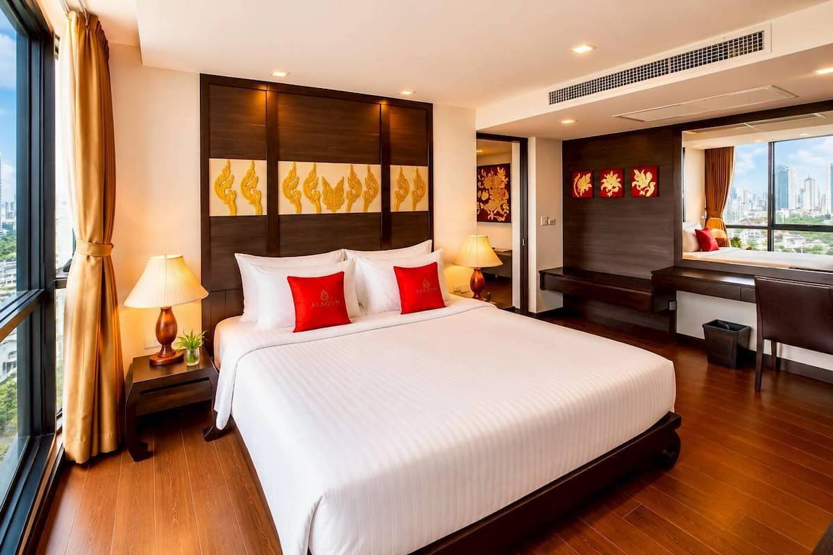 Une chambre d’hôtel avec un grand lit, un bureau et une vue sur la ville.