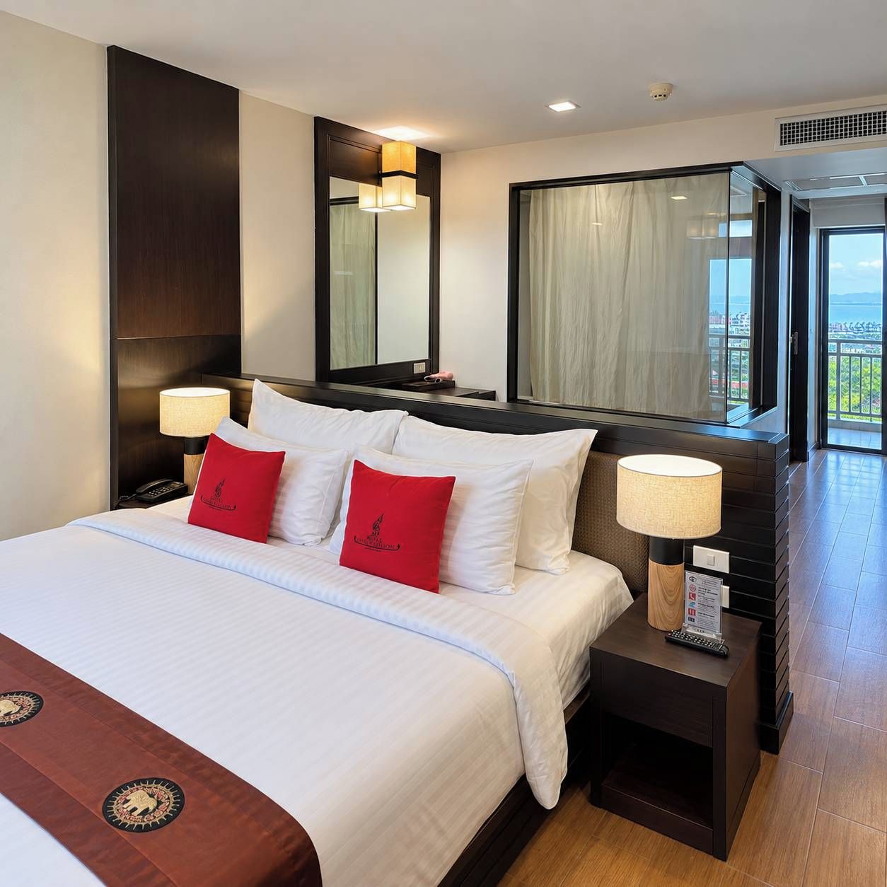A hotel room with a large bed, two bedside tables, a mirror, and a view of the outdoors.