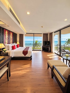 A hotel room with a bed, a TV, a balcony with a view of the ocean, and a dining area. - Royal Thai Pavilion Jomtien Boutique Resort (Pattaya)
