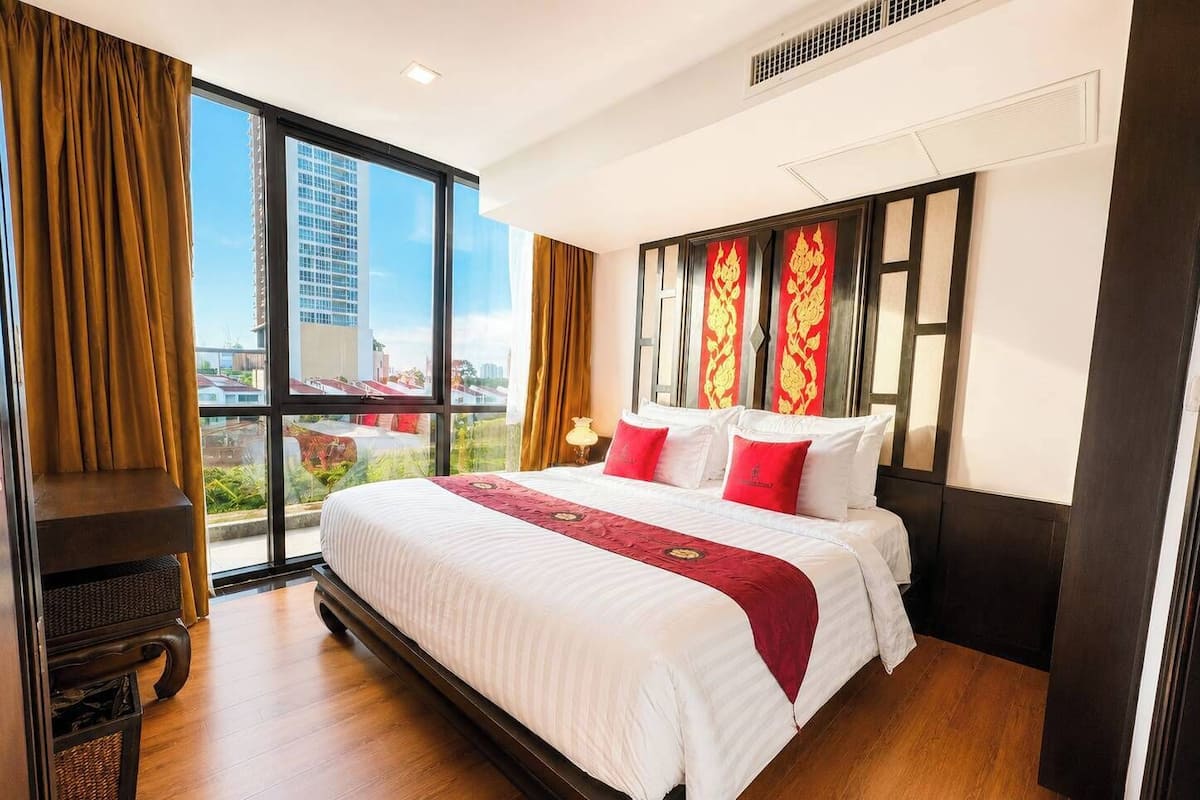 Une chambre d’hôtel avec un grand lit, une vue sur la ville et un balcon.