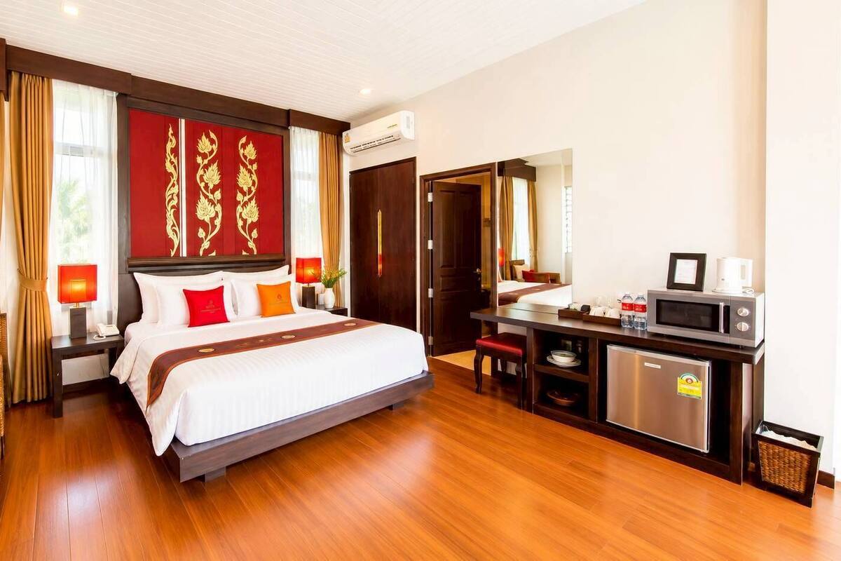 Une chambre d’hôtel équipée d’un lit, d’un bureau, d’un four à micro-ondes et d’un réfrigérateur.