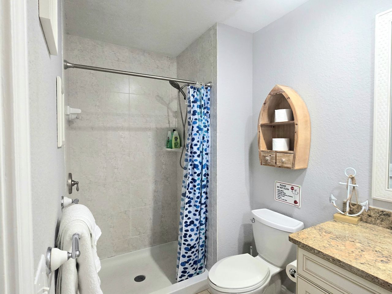 Un bagno con doccia, toilette e un lavabo con specchio.