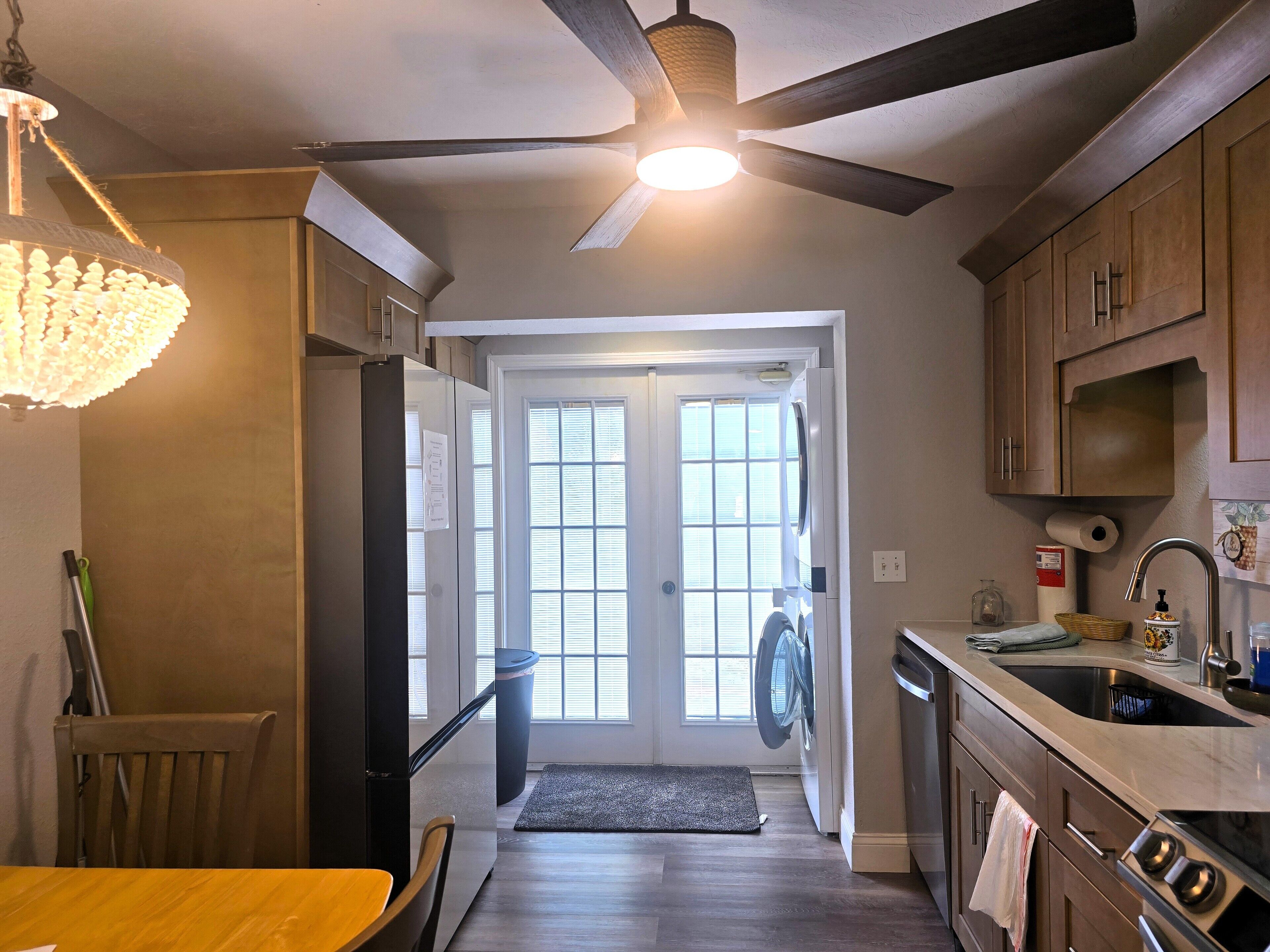 Eine Küche mit Deckenventilator, Waschmaschine und Geschirrspüler.