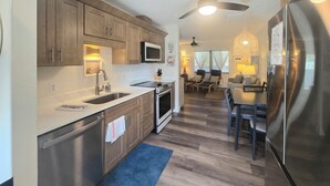 Una cocina moderna con armarios de madera, electrodomésticos de acero inoxidable y una alfombra azul.
