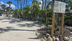 Se ñal de Palm Tree Villas, con un camino de grava y palmeras.