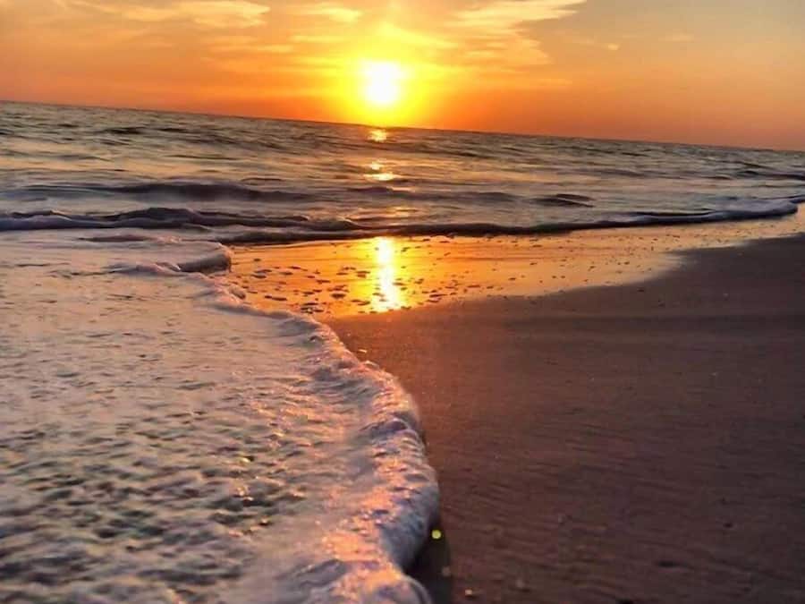Nær stranden, hvit sand, parasoller og strandhåndklær