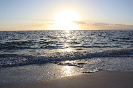 Una playa cerca, arena blanca, sombrillas, toallas de playa. Palm Tree Villas