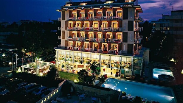 A multi-story hotel with balconies, a pool, and outdoor seating. - Hotel Tridentum (Cesenatico)