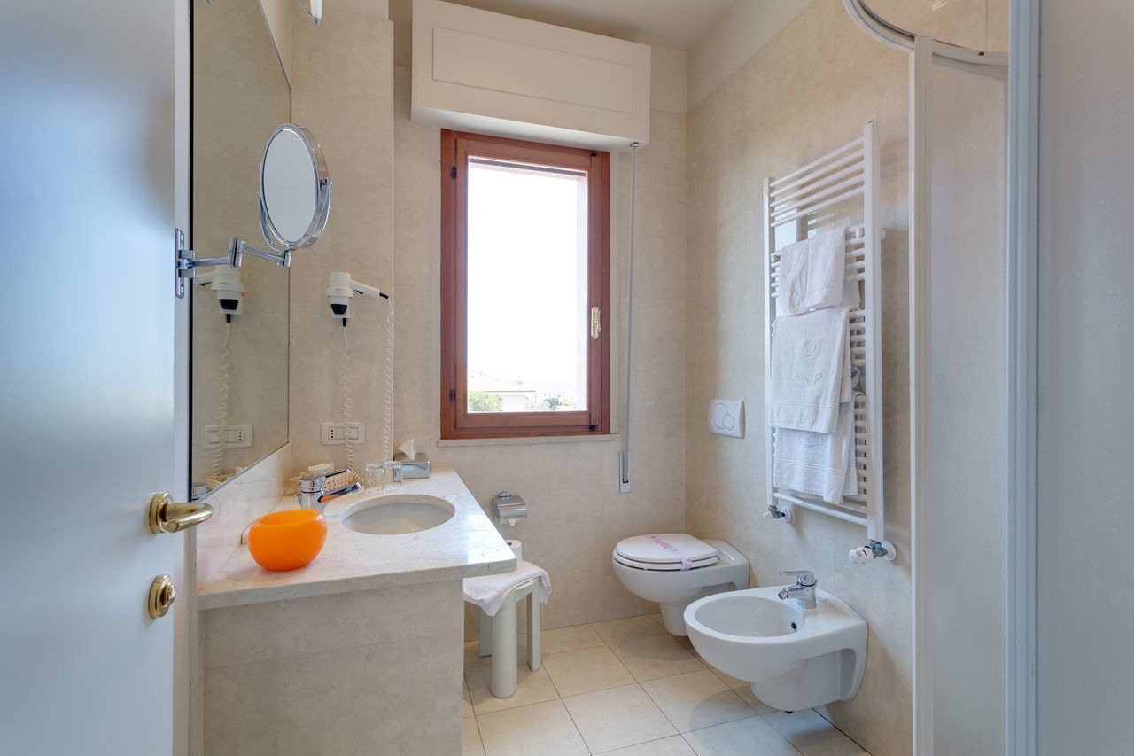 Ein kleines Badezimmer mit einem Doppelwaschbecken, einem Bidet und einer Toilette.