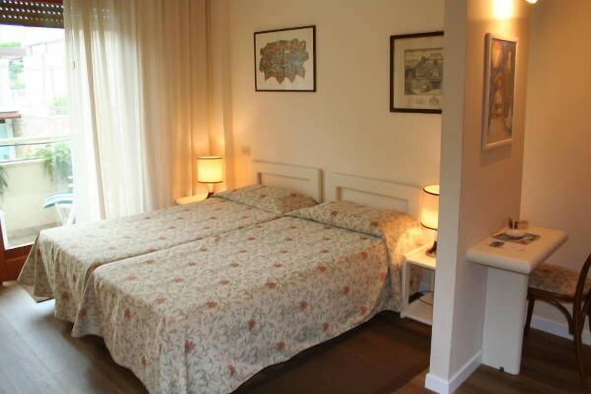 Habitación doble con dos camas, una mesita y una silla.