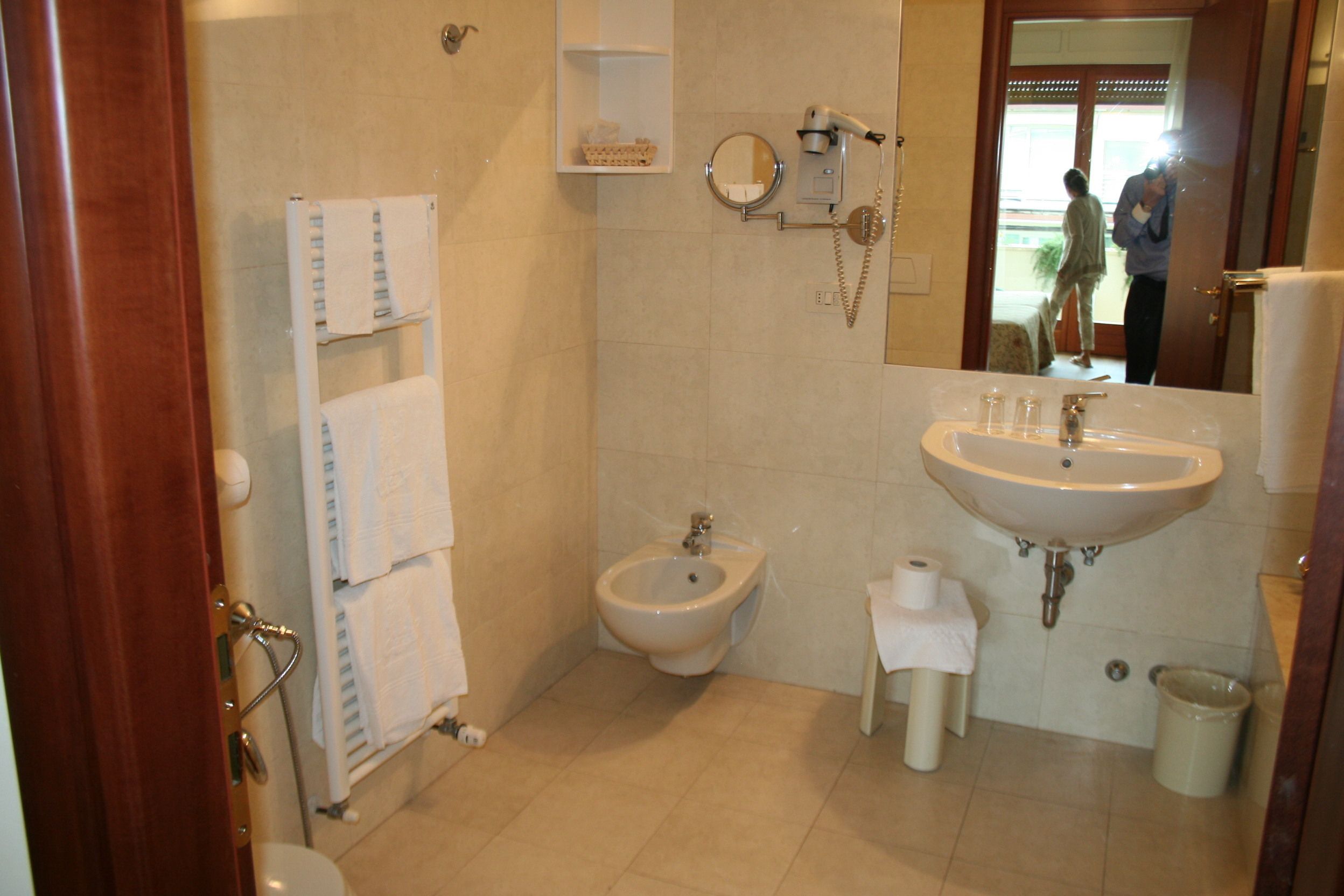 Une salle de bain équipée d’un bidet, d’un lavabo et d’un miroir.