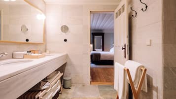 A modern bathroom with a large mirror, a sink, and a towel rack.