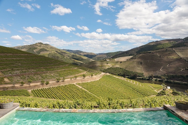 En säsongsöppen utomhuspool och solstolar