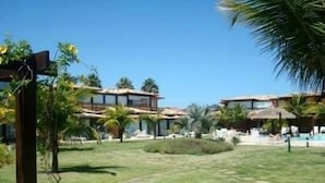 Ein Resort mit mehreren Gebäuden, einem Schwimmbad und Palmen.