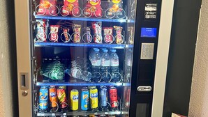 Distributore automatico pieno di snack, bevande e acqua in bottiglia.