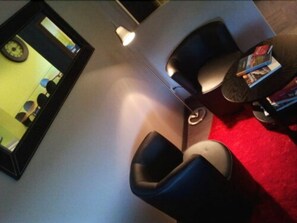 Relax in this stylish room with a sofa, table, and wall-mounted clock.