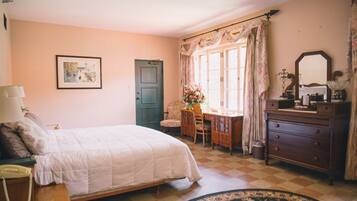 Um quarto com uma cama, uma escrivaninha, uma cômoda e uma cadeira.
