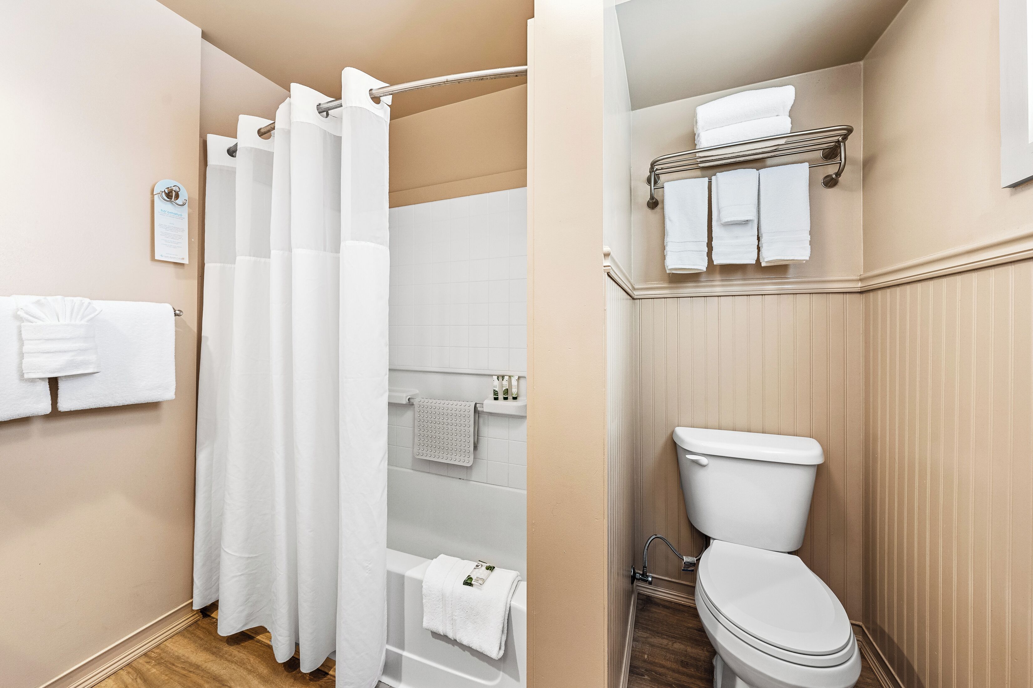 Een badkamer met douche, toilet en handdoekrek.