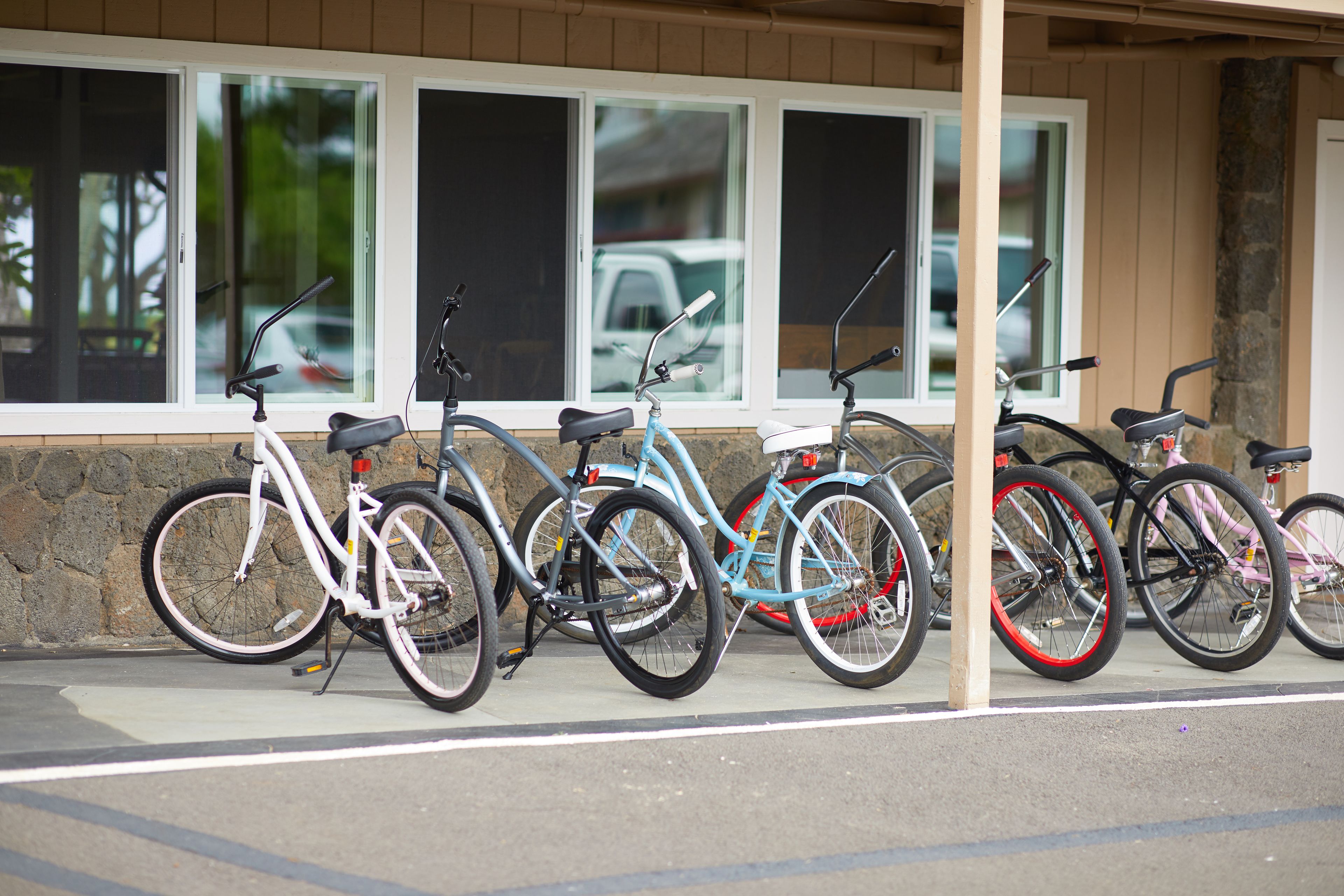 Bicycles parked in front of a building with large windows.