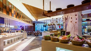 A modern hotel lobby with a buffet area, seating arrangements, and a bar. - Crowne Plaza Sanya City Center by IHG (Sanya)