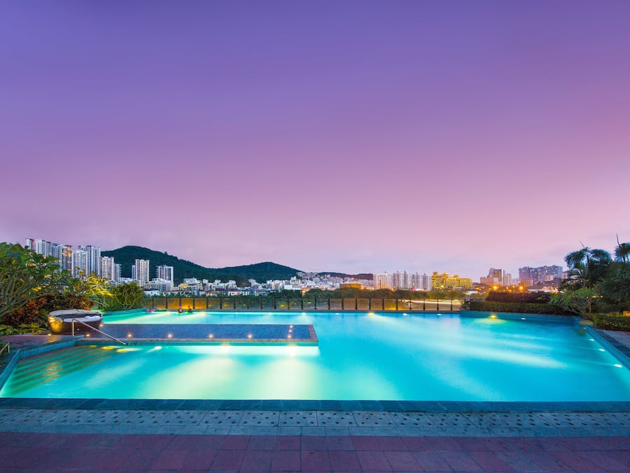 A swimming pool with a cityscape in the background.