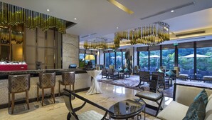 A modern hotel lobby with a bar area, seating arrangements, and large windows offering a view of the outdoors. - Crowne Plaza Sanya City Center by IHG (Sanya)