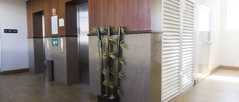 A reception area with a wooden reception desk, a bamboo plant, and a closed sliding door.