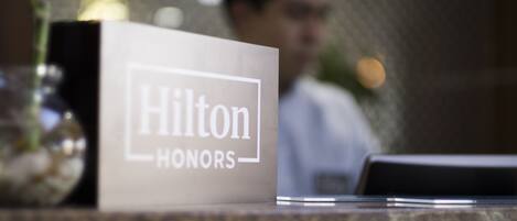 A Hilton Honors sign on a counter with a blurred background.