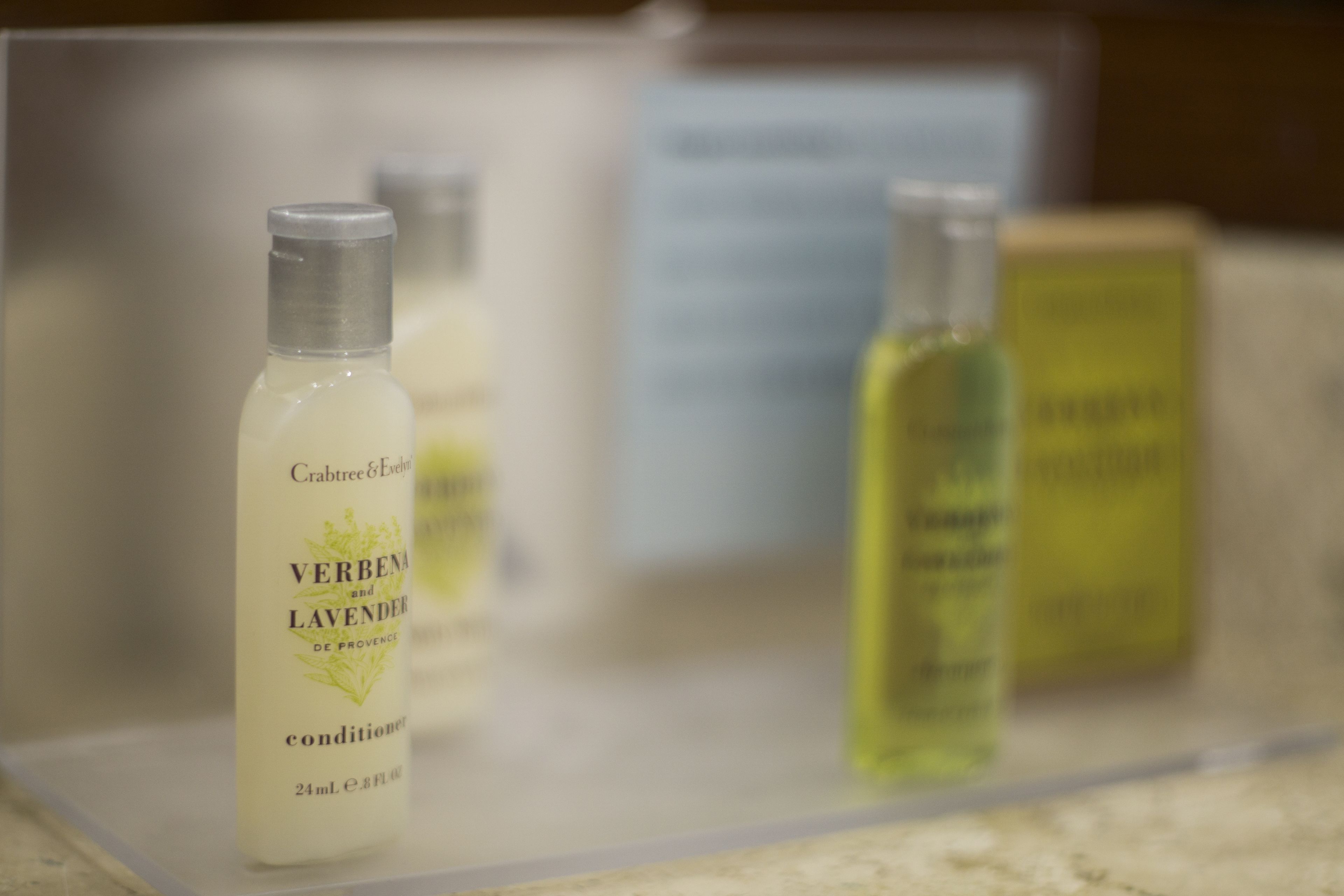 A display of various skincare products, including a bottle labeled "Crabtree & Evelyn VERBENA and LAVENDER DE PROVENCE conditioner."