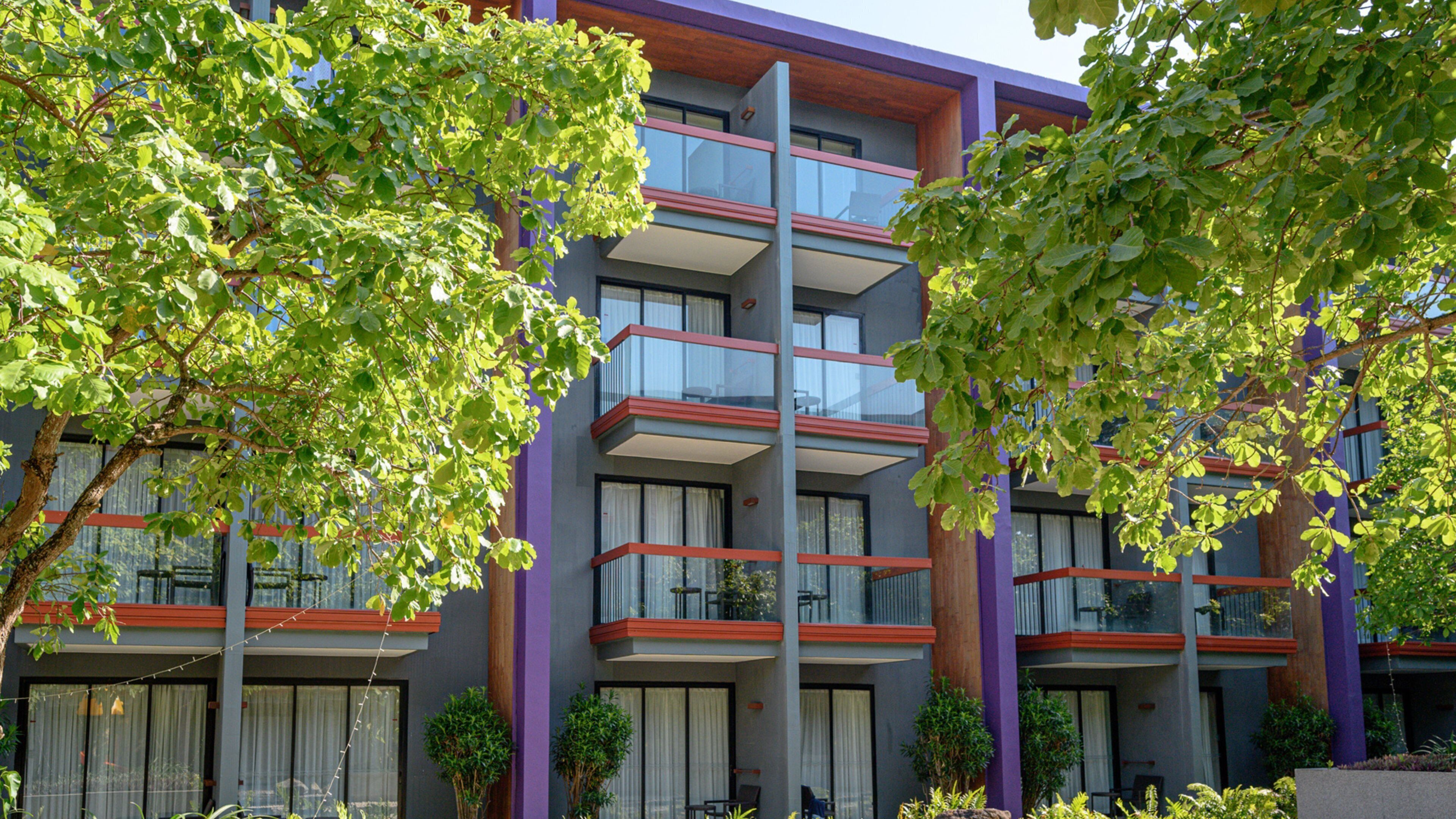 Un edificio de varios pisos con balcones, ventanas amplias y un estilo arquitectónico moderno.