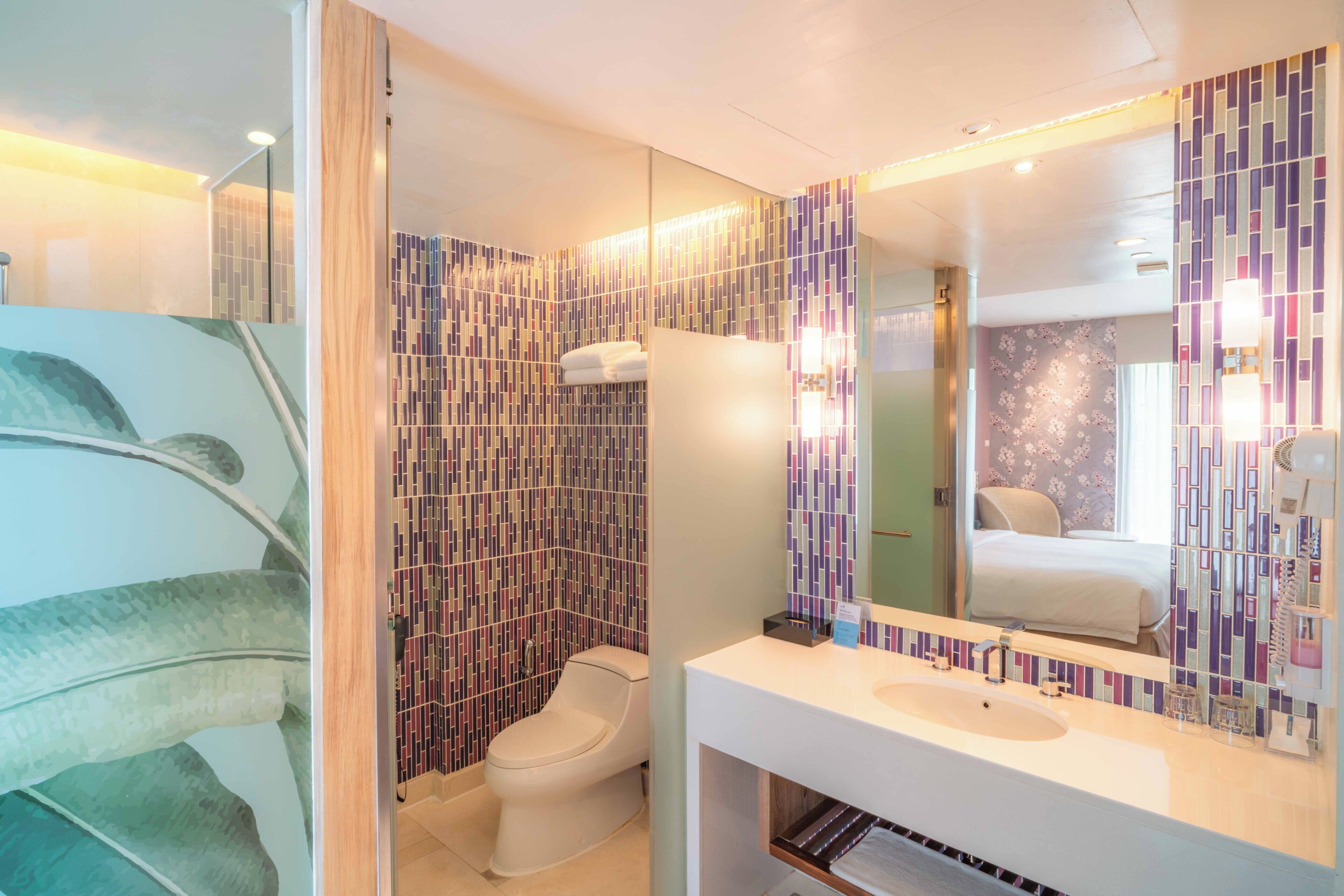 Ein modernes Badezimmer mit Toilette, Waschbecken und Spiegel.