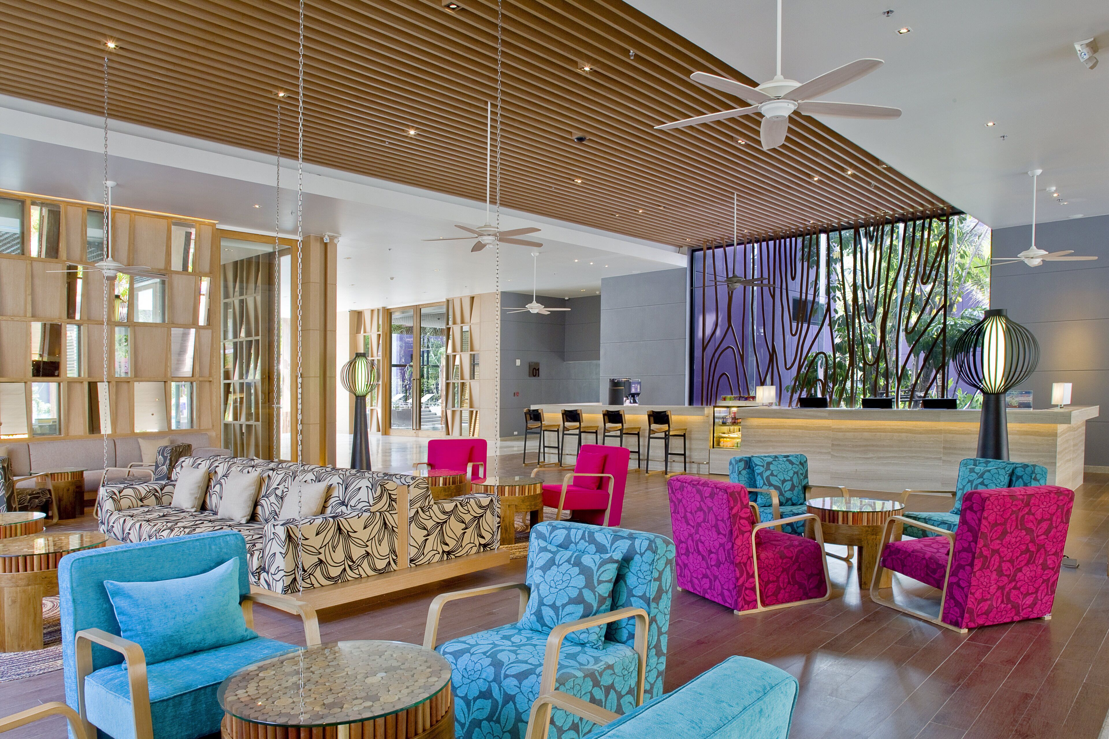 A spacious lobby with seating areas, a reception desk, and a large window with natural light.