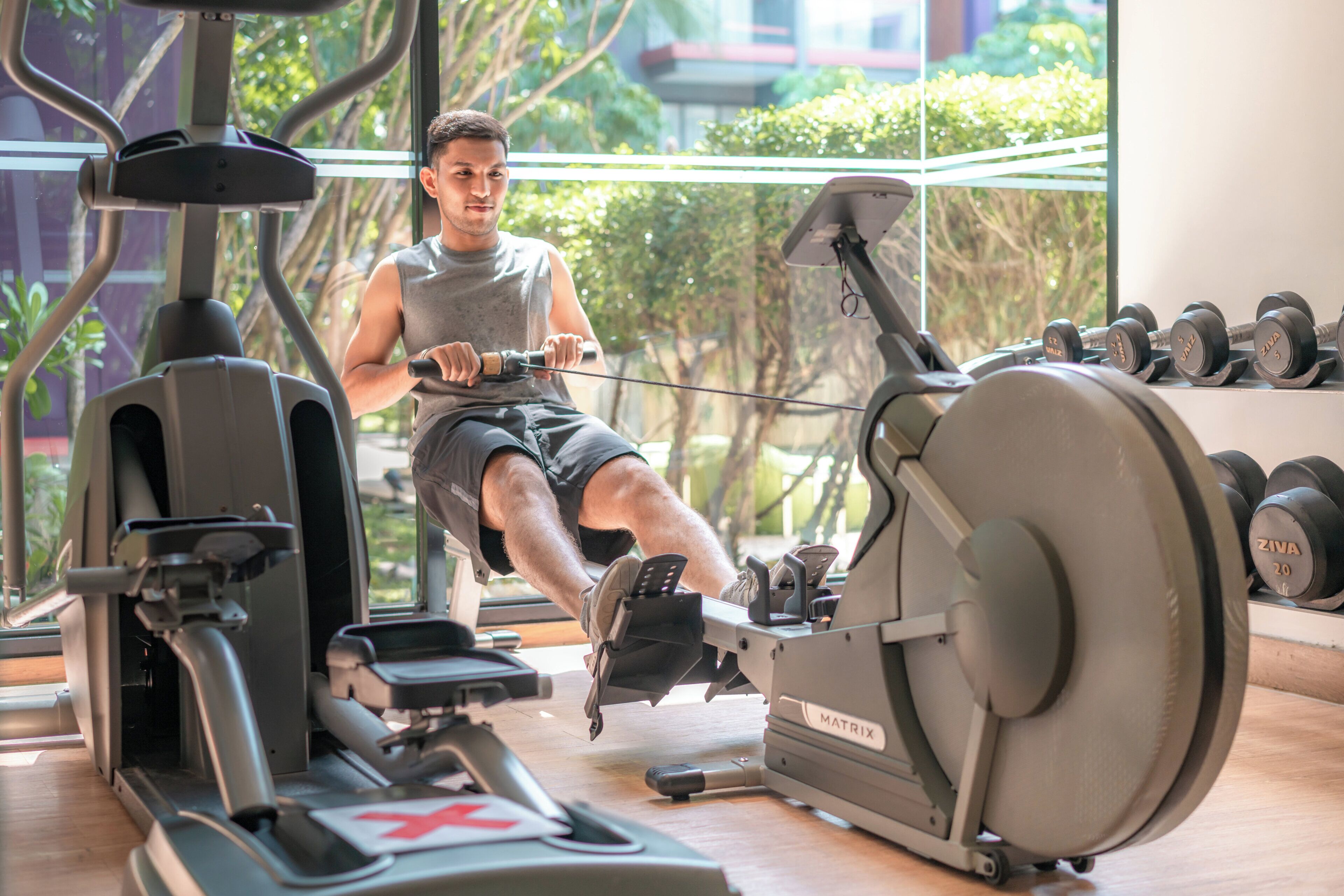 A gym with exercise equipment, including a rowing machine and dumbbells.