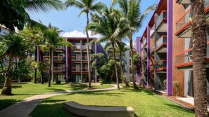 A modern hotel with multiple floors, surrounded by palm trees and a well-maintained garden. - Holiday Inn Express Phuket Patong Beach Central by IHG (Patong)