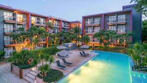 A modern hotel with a pool area, multiple balconies, and lush greenery. - Holiday Inn Express Phuket Patong Beach Central by IHG (Patong)