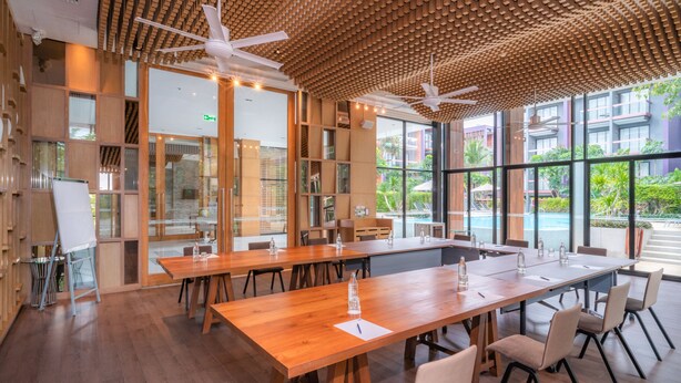 A modern conference room with wooden tables and chairs, large windows, and ceiling fans. - Holiday Inn Express Phuket Patong Beach Central by IHG (Patong)