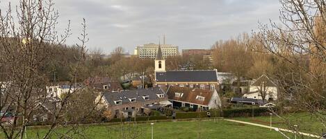 A residential area with houses, a church, and a large building in the background.